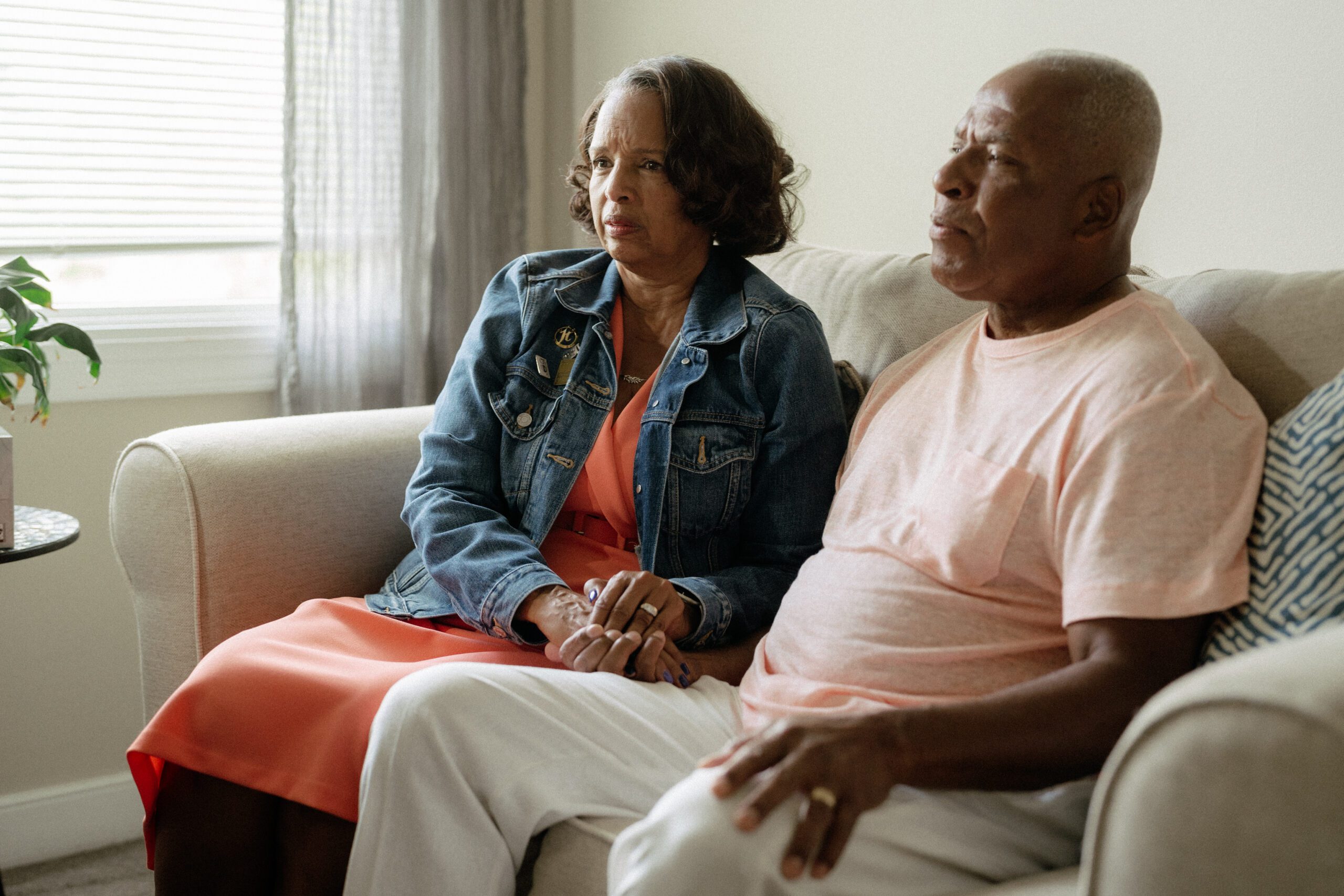 couple_sitting_on_couch_holding_hands